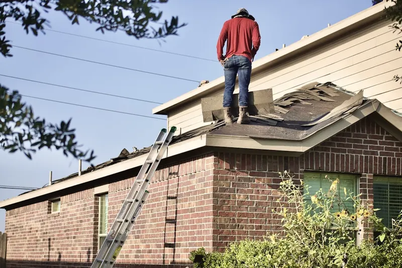 Professional roofer working on a residential roof in North Bellport